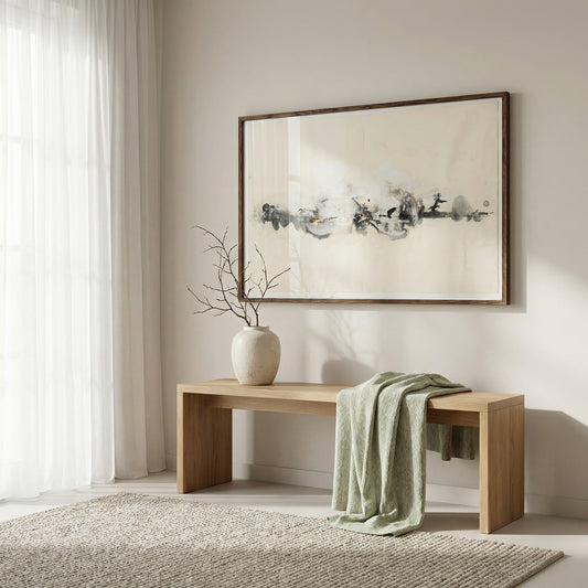 Wooden bench with a vase and green blanket in front of a framed abstract painting on a wall.