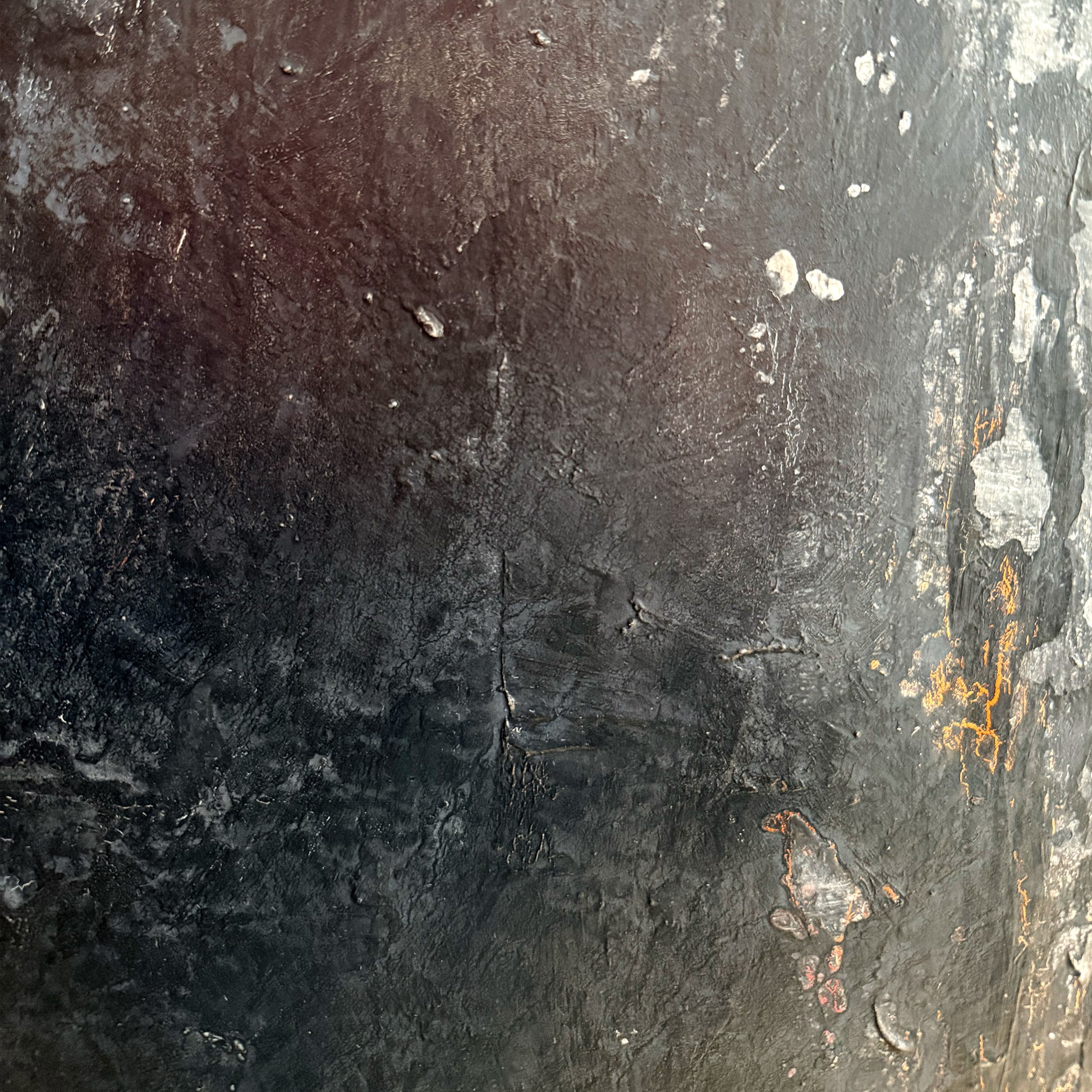 Close-up of a textured dark surface with some white and orange markings