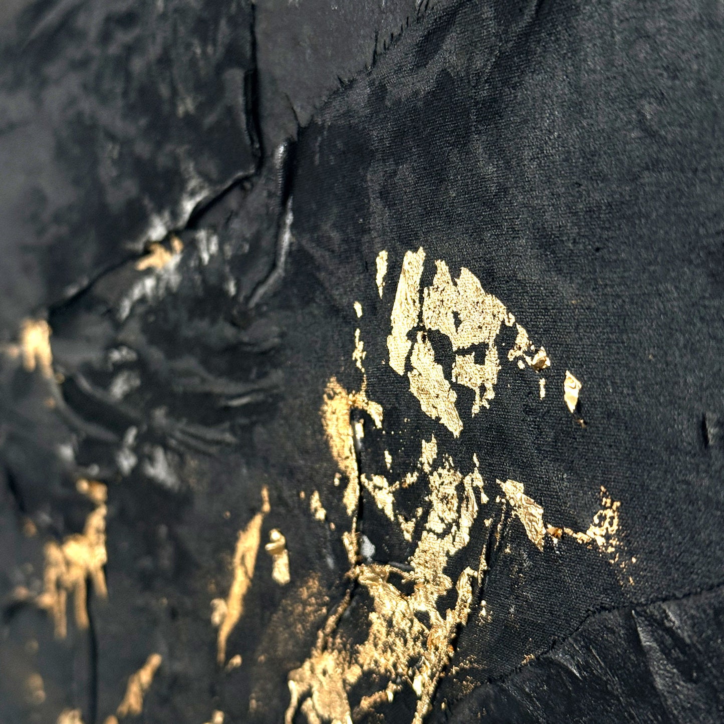 Close-up of a black fabric with gold paint splashes
