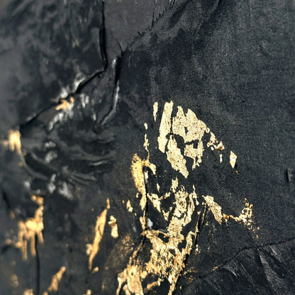 Close-up of a black fabric with gold paint splashes