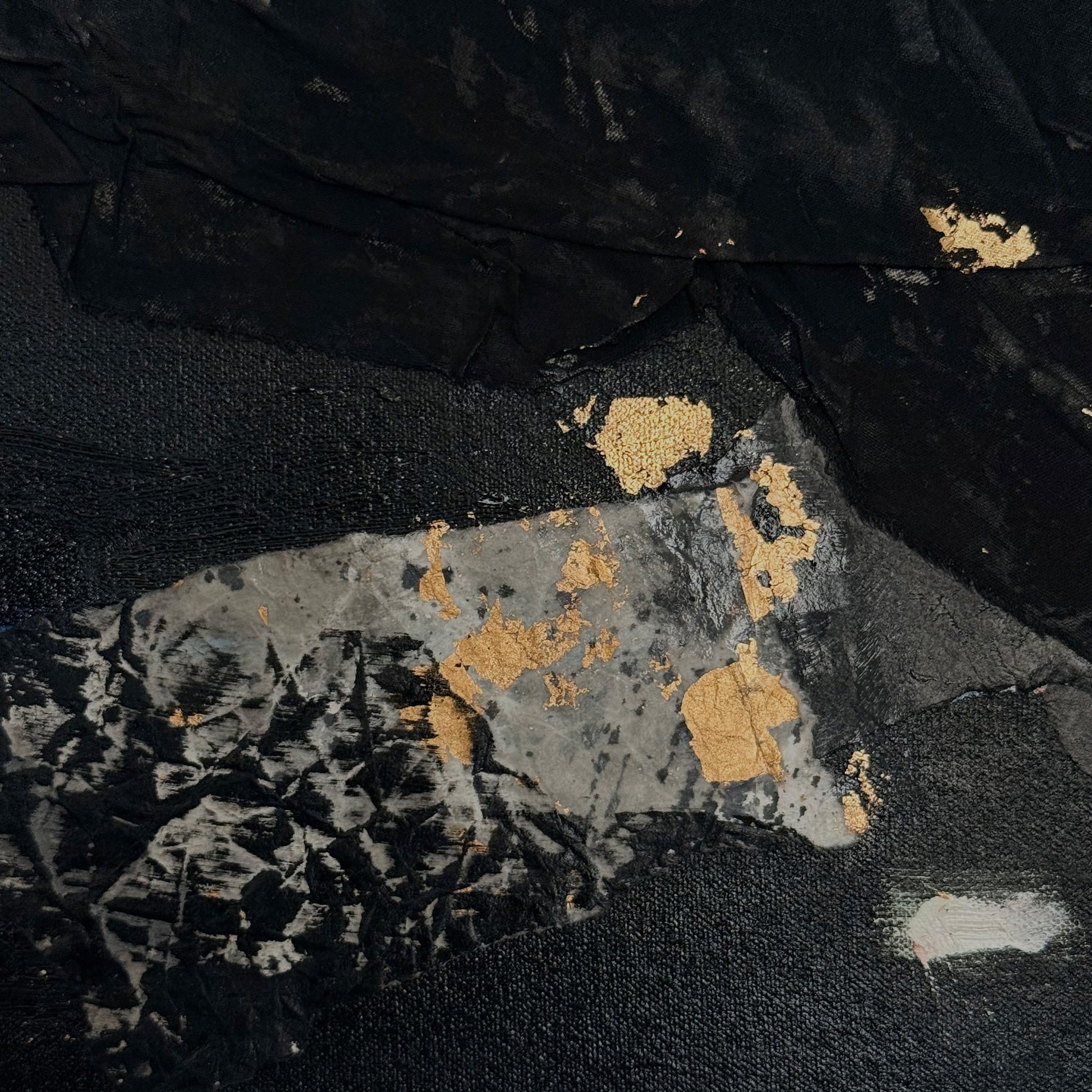 Textured fabric with gold and silver patterns on a black background