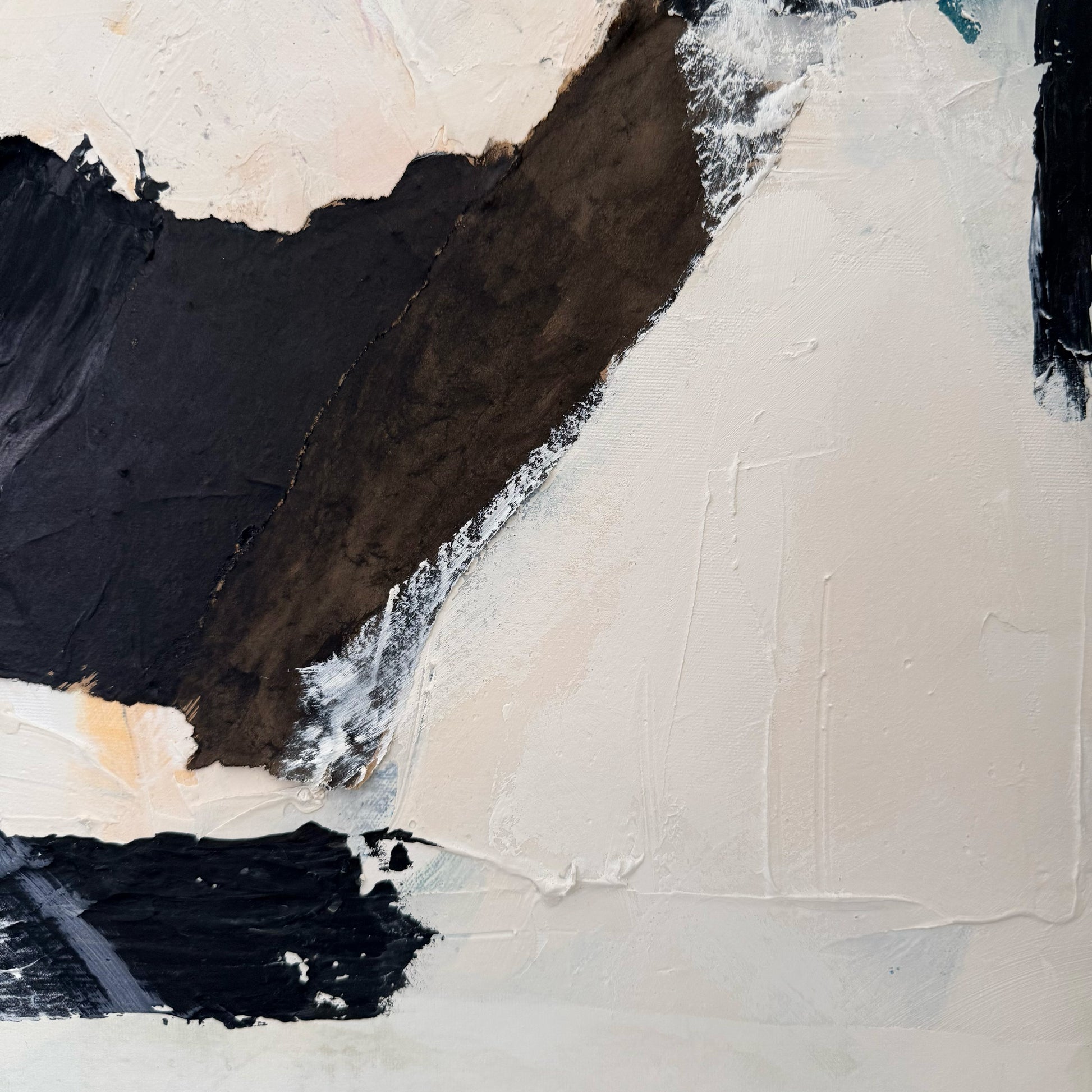 Abstract art piece with black, white, and beige colors on a textured surface