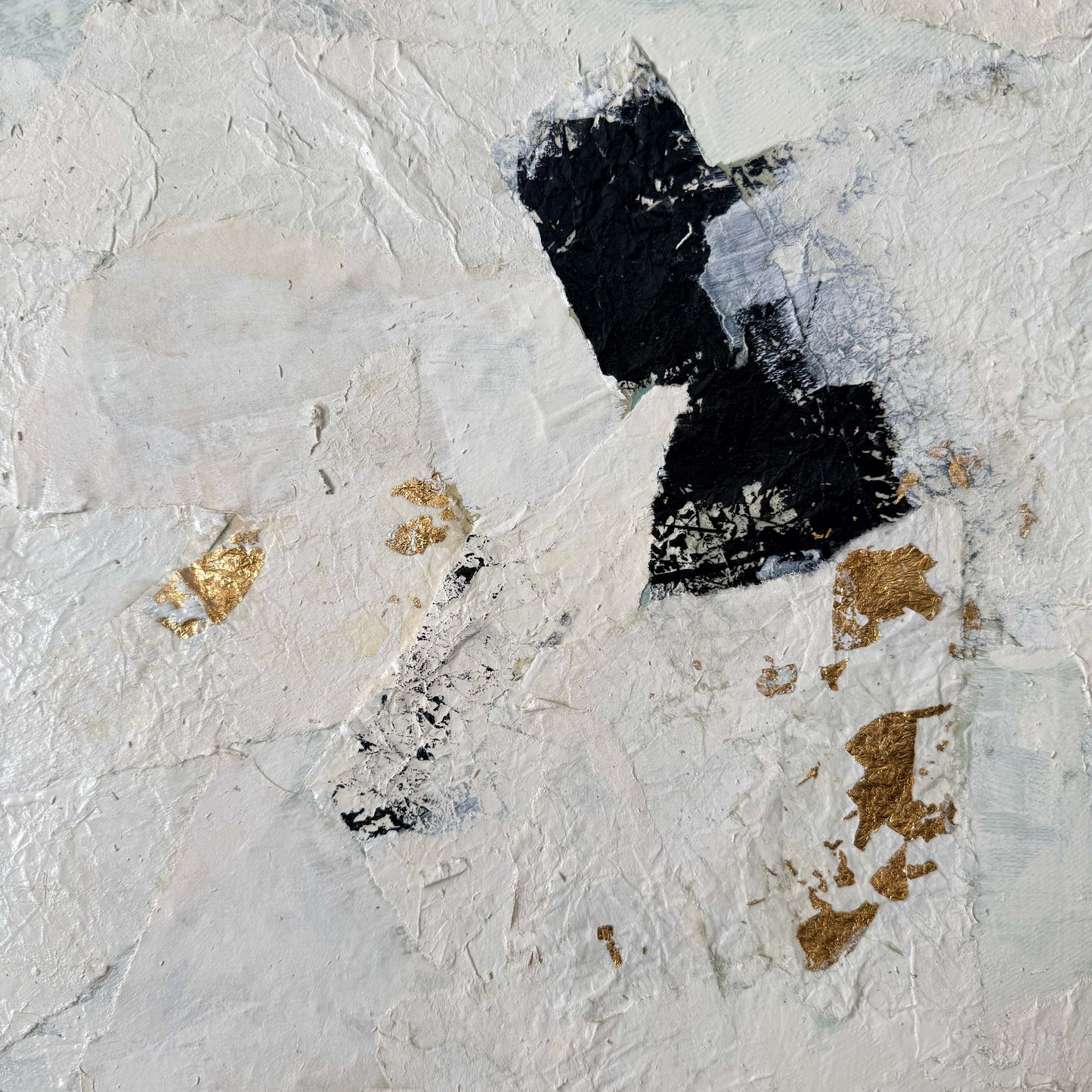 Abstract art piece with black and gold elements on a textured white background