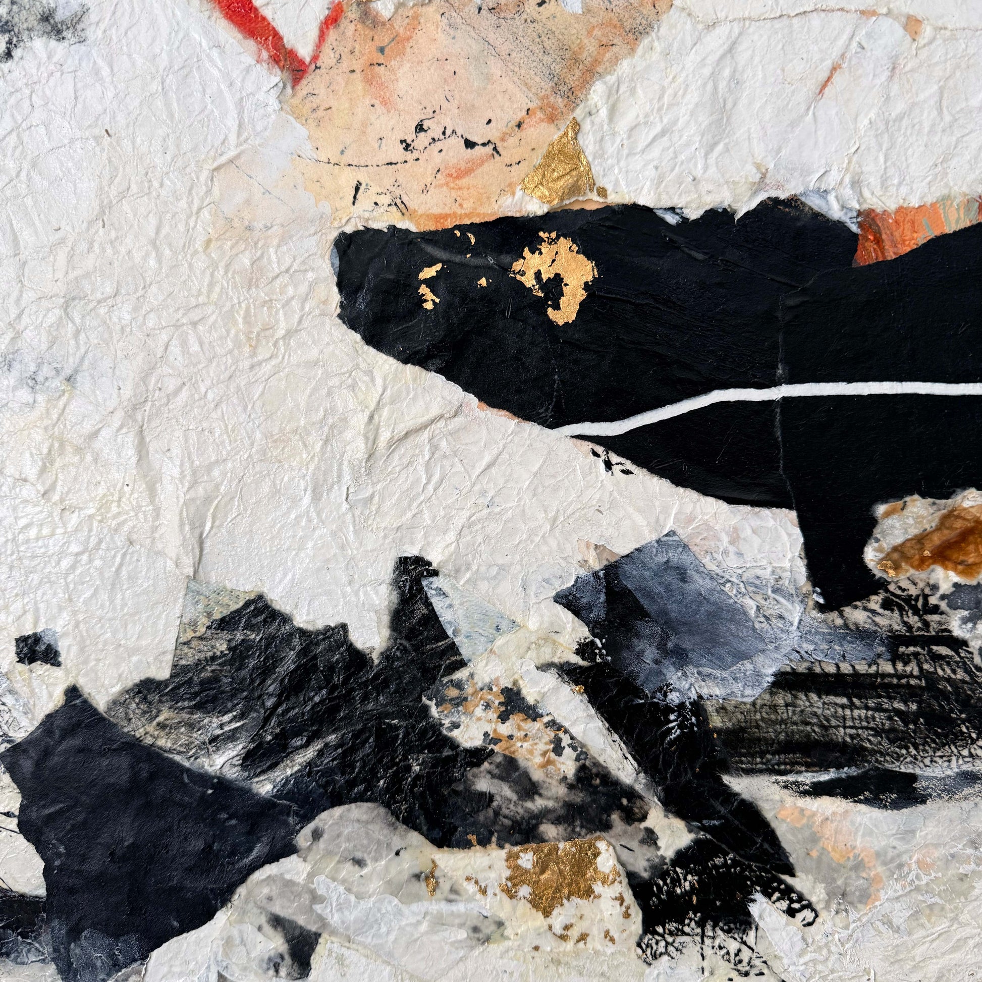 Abstract art piece with black and white shapes on a textured surface