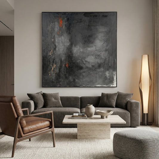 Modern living room with gray sofa, brown armchair, and abstract painting on wall.