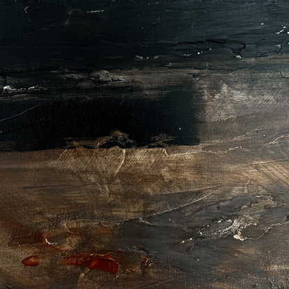 Close-up of a dark, textured surface with visible grain and color variations.