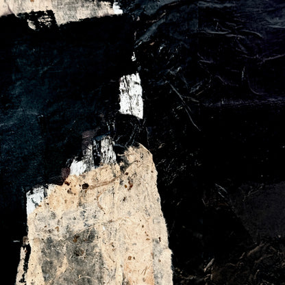 Aerial view of a lighthouse on a rocky island with dark water surrounding it.